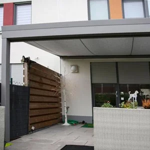Terrassenüberdachung mit integrierter Unterdachmarkise, angebracht an einem modernen Wohngebäude.
